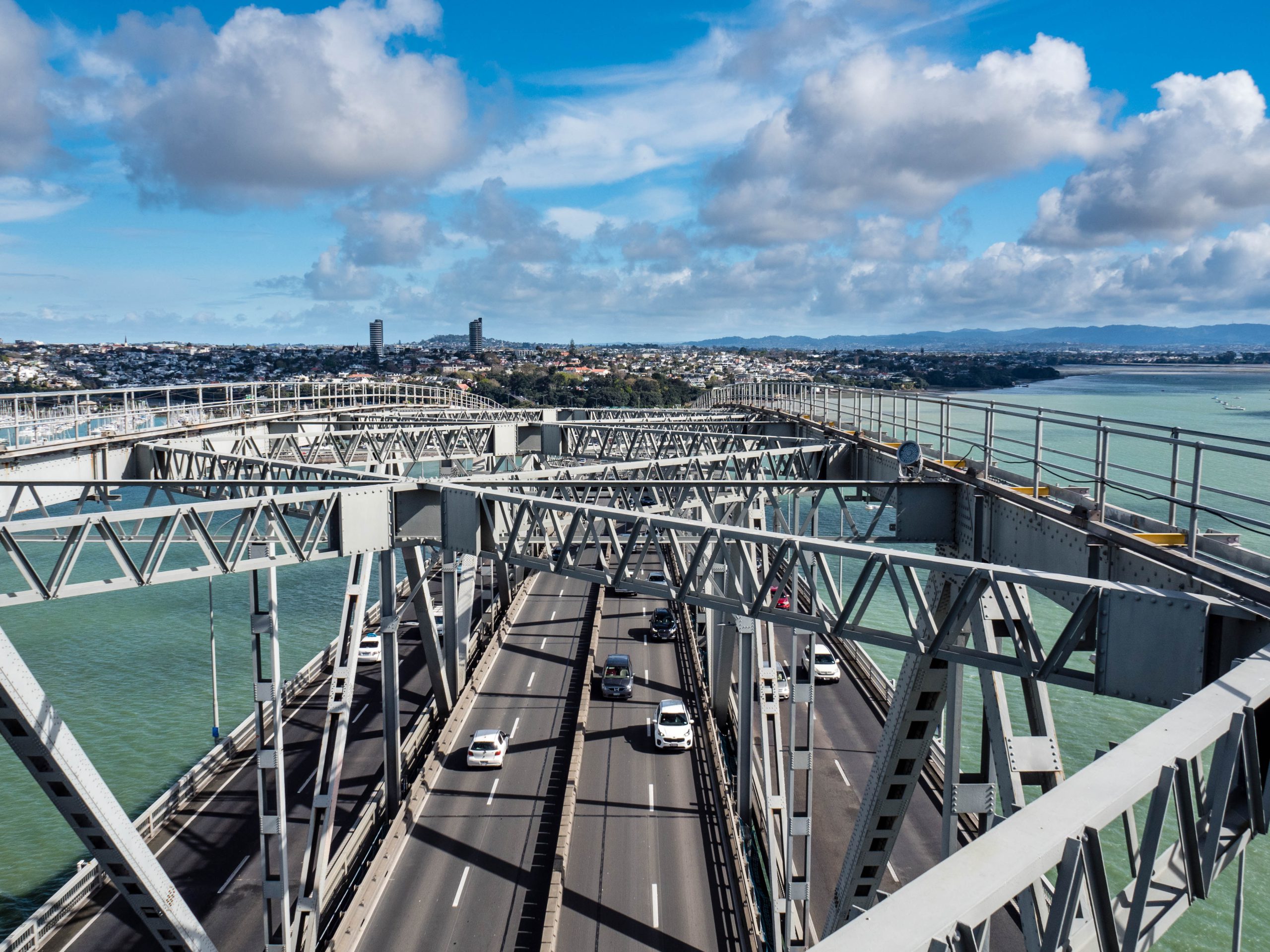 a view from above of traffic passing over the Auckland Harbour Bridge.